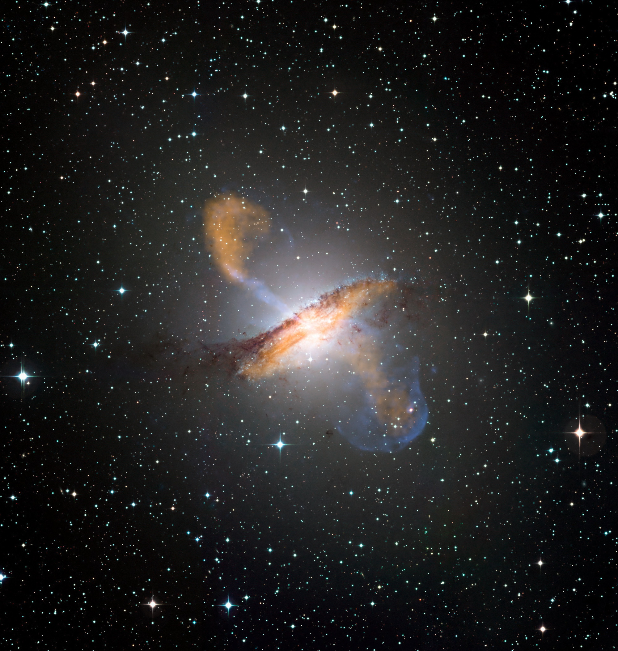 Eine Überlagerung von Aufnahmen in verschiedenen Wellenlängenbereichen zeigt die Galaxie Centaurus A, ihr Staubband und die Jets, die vom zentralen Schwarzen Loch ausgehen