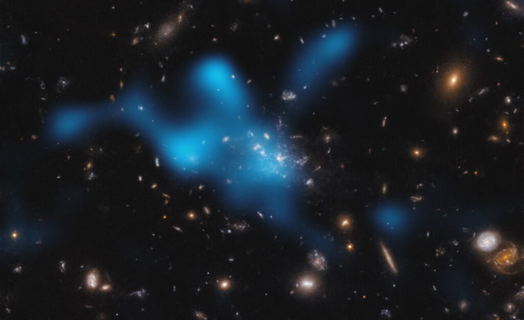 Der Aufnahme eines Galaxienhaufens im sichtbaren Licht ist eine blaue Wolke überlagert, die das im Radiowellenbereich registrierte heiße Gas zwischen den Galaxien illustriert.